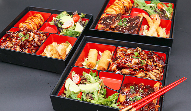 teriyaki chicken bento boxes with variety of cooked food