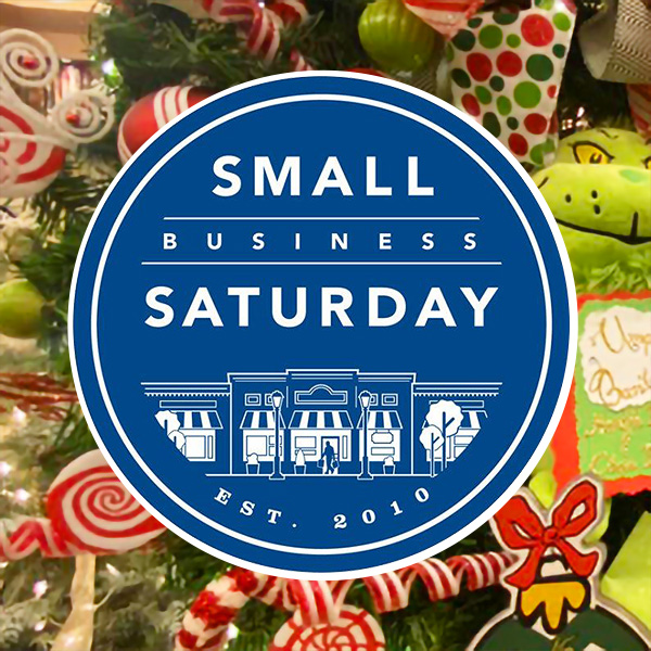 a blue and white circle with the text inside of it "small business Saturday" imposed upon a red white and green holiday background,