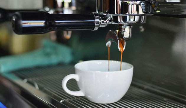 white espresso cup being filled with coffee