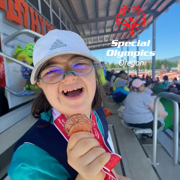 image of special olympics competitor holding their winners medal