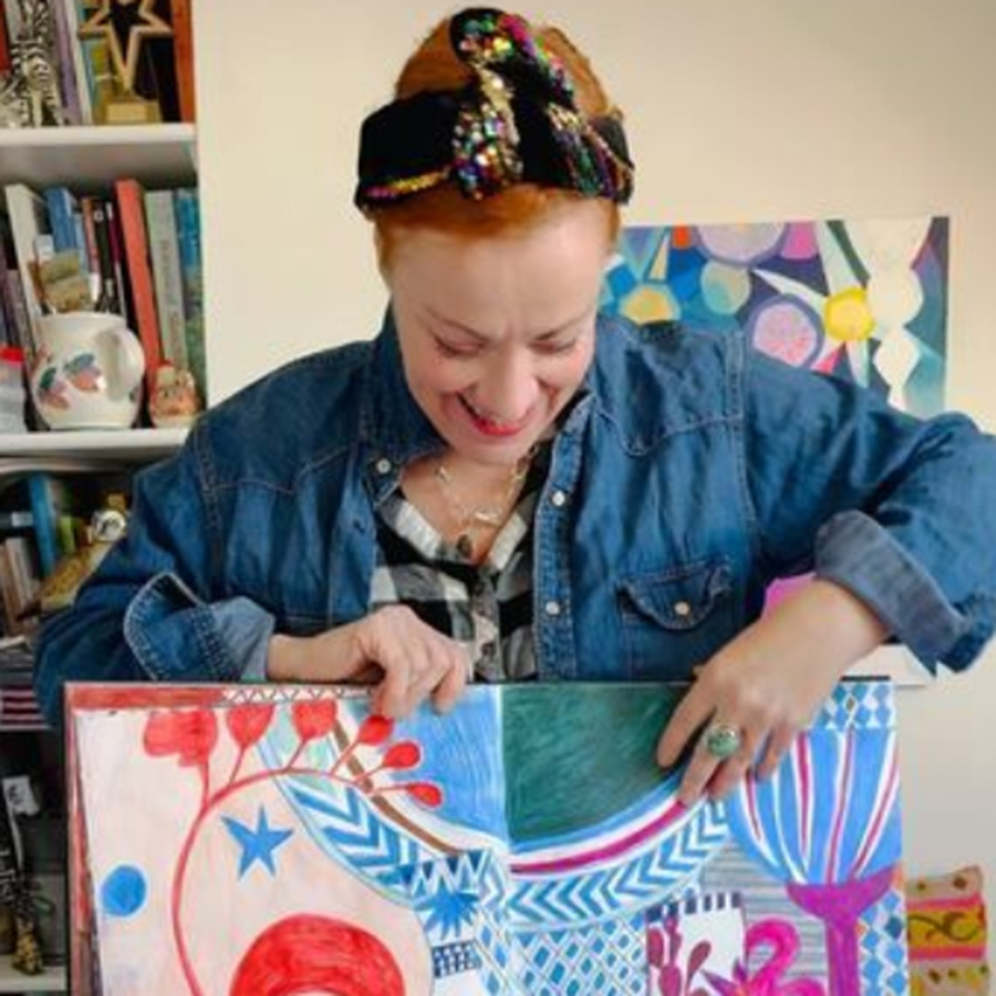 woman in a denim shirt holding an illustrated book
