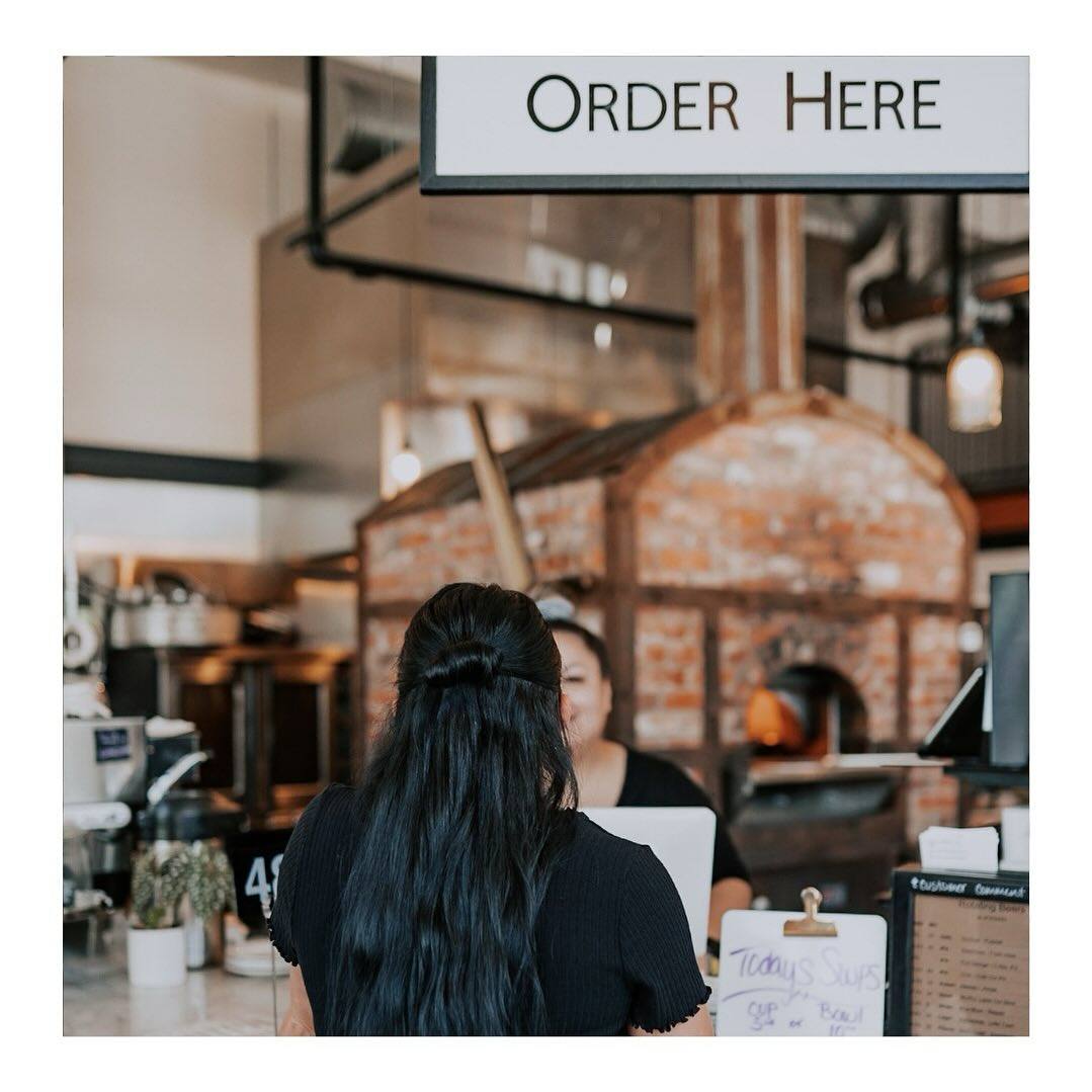 person orders at the counter of restaurant