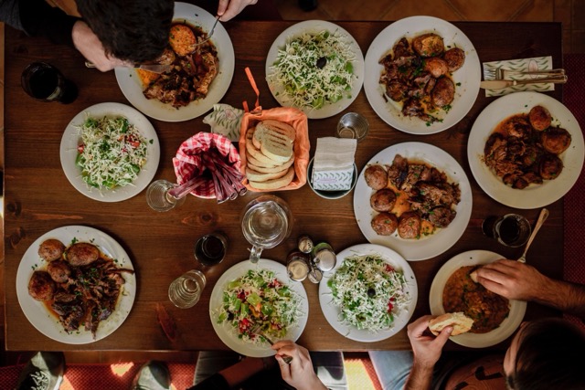 overhead view of people at a table with many plates of food
