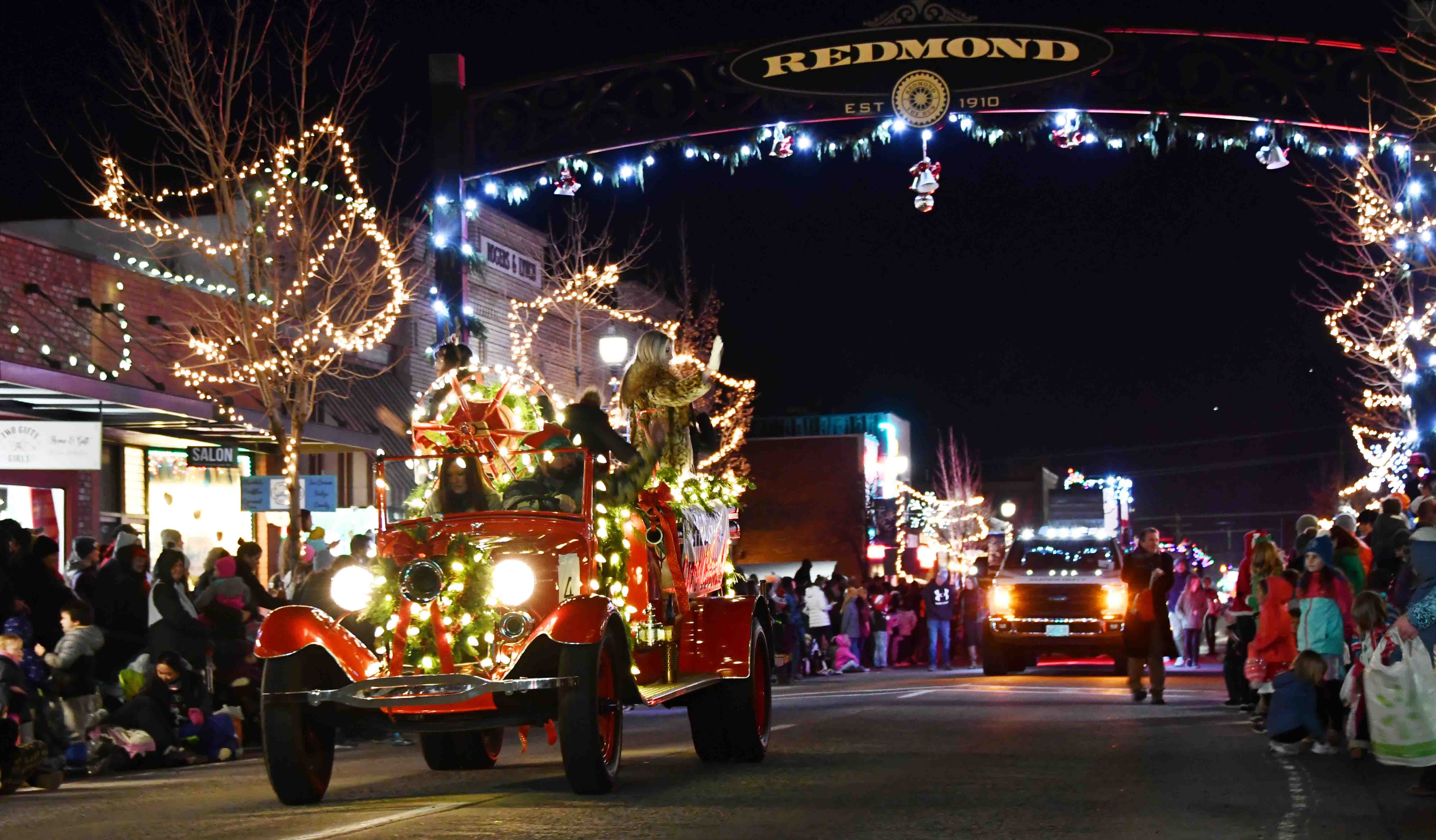 A parade of christmas decorated cars down the main street in Redmond