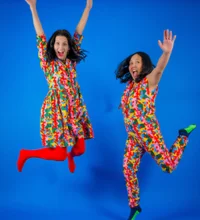 Two people jumping in the air wearing colorful outfits