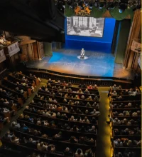 Birds eye view of an auditorium with a man on a stage