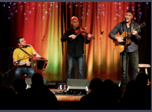 Three men with an accordian, violin, guitar