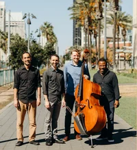 Group of people with one holding a bass instrument