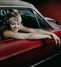 Haley Johnsen leaning out of a red car