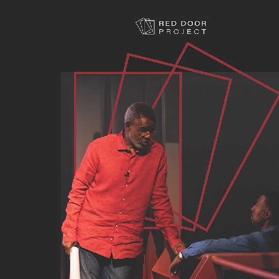 a man in a red shirt reaching for the hand of another man