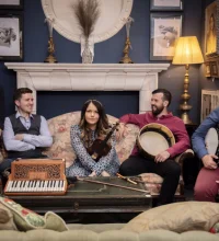 members of Goitse sitting on a sofa holding their instruments