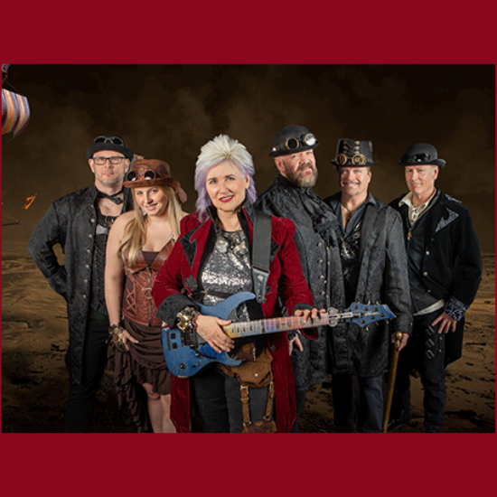 woman in a red coat with a guitar and five people dressed in steampunk attire behind her