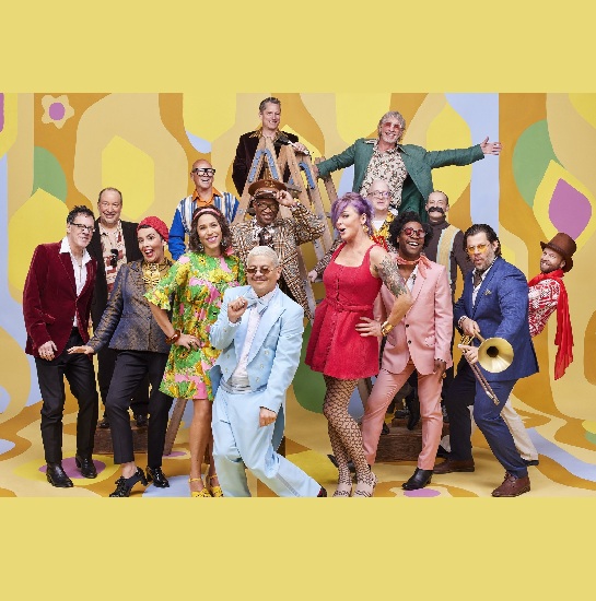 The members of the band, Pink Martini, against a colorful backdrop