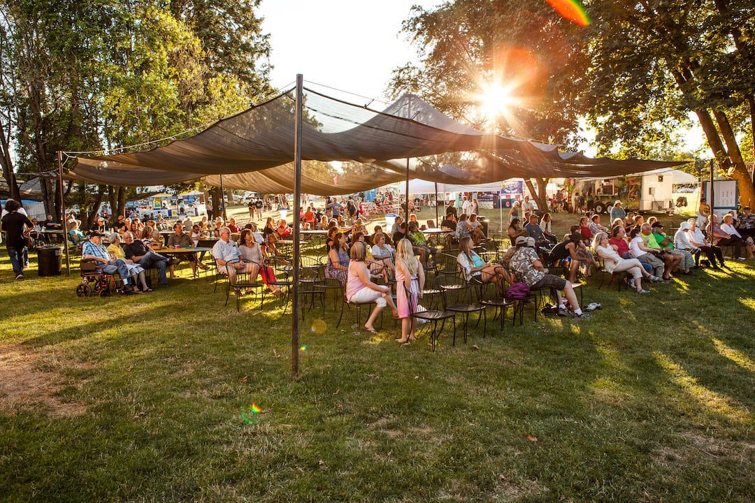 People gathered under a an outdoor tent.