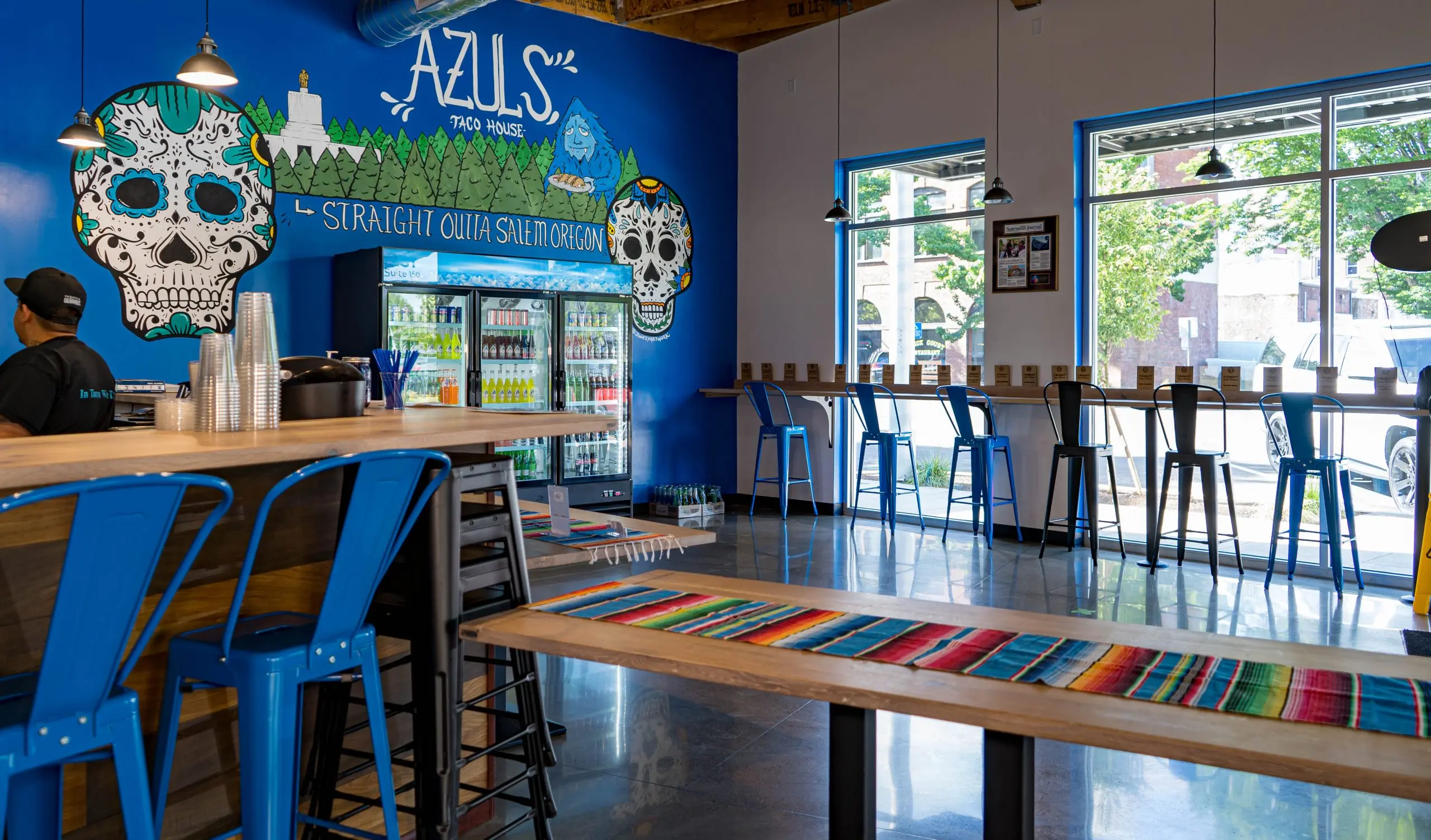 Interior of Azul's Taco House, blue wall with skull art, tables and chairs in an open restaurant space