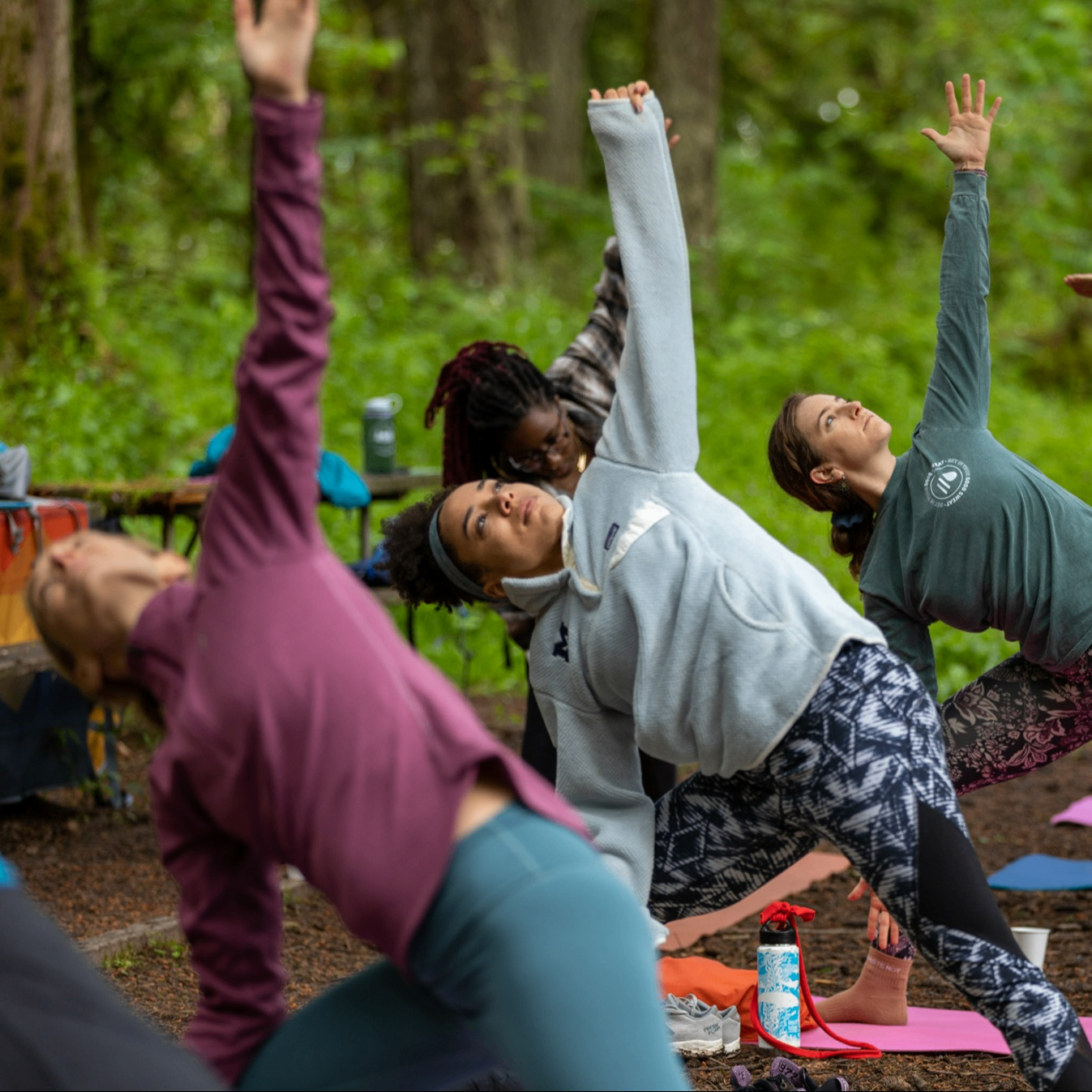 Group of people doing yoga in a forest.