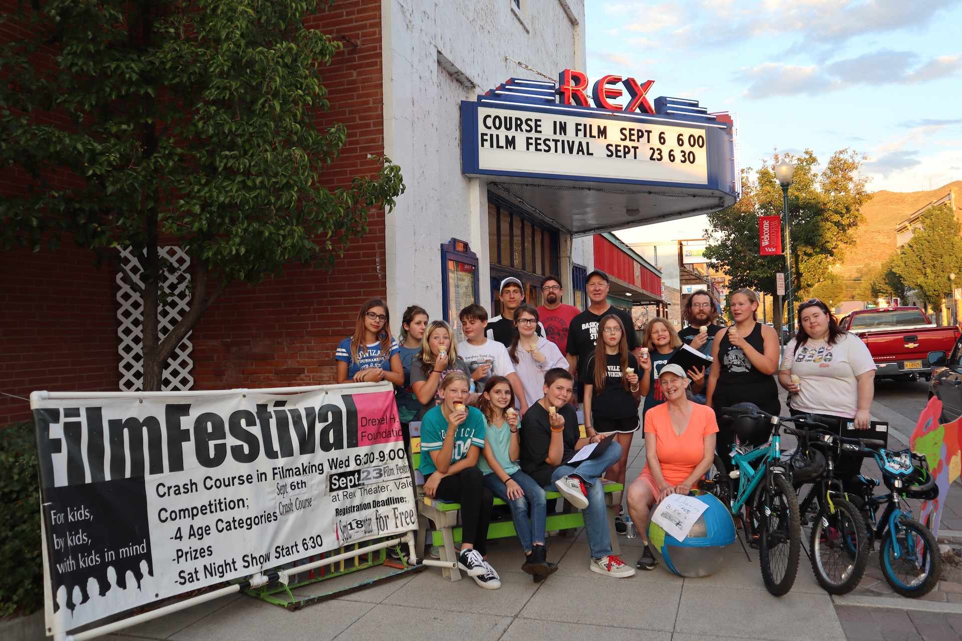 A group of kids and mentors eating ice cream outside the Rex Theater