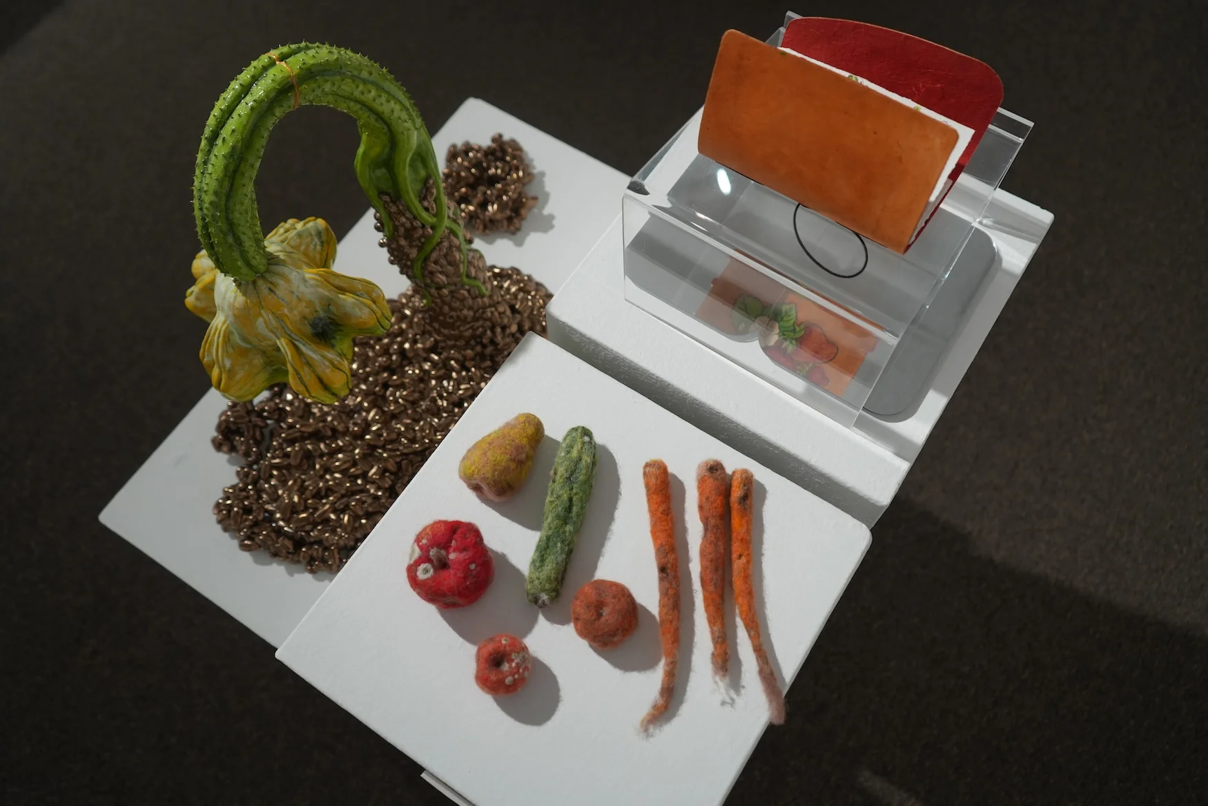 Sculptures in various mediums showcase different foods such as squash, tomatoes, carrots, and peppers.